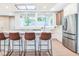 Bright kitchen featuring a large center island with bar stool seating and stainless steel refrigerator at 625 E 57Th St, Indianapolis, IN 46220