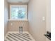The laundry room includes tile floors, a window for natural light, and hookups for a washer and dryer at 625 E 57Th St, Indianapolis, IN 46220