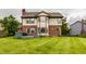 Well-maintained backyard showcasing a brick and siding two-story home with a gray wooden deck at 6307 Keeneland Ct, Indianapolis, IN 46278