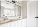Bathroom featuring double sinks, a large mirror, and white cabinets, illuminated by natural light at 6307 Keeneland Ct, Indianapolis, IN 46278