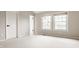 Neutral bedroom featuring two windows, new carpeting, and a crisp white door at 6307 Keeneland Ct, Indianapolis, IN 46278