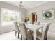 Sunlit dining room featuring a white table, tufted chairs, and large windows with lush green views at 6307 Keeneland Ct, Indianapolis, IN 46278