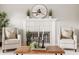 Close-up shot of a fireplace, chairs, decorative accents, and a round mirror above at 6307 Keeneland Ct, Indianapolis, IN 46278