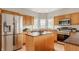 Spacious kitchen featuring stainless steel appliances and wood cabinetry with a breakfast bar at 6307 Keeneland Ct, Indianapolis, IN 46278