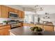 Kitchen with stainless appliances, wood cabinets, and breakfast bar open to the living room at 6307 Keeneland Ct, Indianapolis, IN 46278