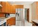 Well lit kitchen with stainless steel fridge, wooden cabinets, and white tiled floor at 6396 Granny Smith Ln, Avon, IN 46123