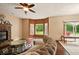 Cozy living room with hardwood floors, fireplace, large windows, and a comfortable sectional couch at 6396 Granny Smith Ln, Avon, IN 46123