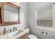 Powder room with a framed mirror, toilet, and window at 671 Sonoma Ln, Greenfield, IN 46140