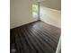 Comfortable bedroom featuring dark wood-look flooring, a large window, and a sliding closet door at 6744 Redan Dr, Indianapolis, IN 46254