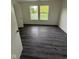 Bright bedroom featuring two windows with views of the outdoors and wood-look flooring at 6744 Redan Dr, Indianapolis, IN 46254