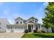 Beautiful two-story home with a three car garage, dormer windows, well maintained lawn, and welcoming blue front door at 6830 Park Grove Blvd, Whitestown, IN 46075