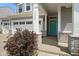 Inviting front entrance with a teal door, stone accents, and an attached two-car garage at 6830 Park Grove Blvd, Whitestown, IN 46075