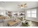 Spacious living room with open floor plan, hardwood floors, ceiling fan, comfortable furniture, and stairs leading to the upper level at 6830 Park Grove Blvd, Whitestown, IN 46075