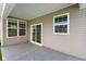 Covered patio with gray floor and beige siding, windows and a sliding glass door at 6830 Park Grove Blvd, Whitestown, IN 46075