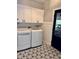 Laundry room featuring modern appliances, custom floor, and ample cabinet storage at 6862 Riverside Way, Fishers, IN 46038