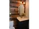 Half bathroom features a rustic wood accent wall, black vanity, and white countertop at 6862 Riverside Way, Fishers, IN 46038
