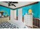 Bright bedroom featuring unique blue walls, ceiling fan, and a cozy quilted bed at 69 Stoneybrook Dr, Greenwood, IN 46142