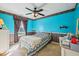 Vibrant bedroom featuring blue walls, a ceiling fan, and a patterned quilt on the bed at 69 Stoneybrook Dr, Greenwood, IN 46142