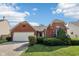 Charming brick home featuring a two-car garage, landscaped yard, and eye-catching architectural details at 69 Stoneybrook Dr, Greenwood, IN 46142