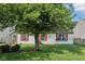 Charming single-story home featuring a well-manicured lawn, bright red shutters, and shade tree at 69 Stoneybrook Dr, Greenwood, IN 46142