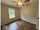 This bedroom features a window overlooking the green yard and wood look floors at 7022 Cordova Dr, Indianapolis, IN 46221
