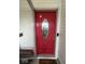 Vibrant red front door with decorative glass, a secure doorbell, and a welcoming entrance mat at 7022 Cordova Dr, Indianapolis, IN 46221