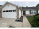 Inviting exterior with a two-car garage and neat landscaping leading to the front door at 7022 Cordova Dr, Indianapolis, IN 46221