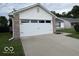 Spacious two-car garage with a clean, concrete driveway and tidy landscaping at 7022 Cordova Dr, Indianapolis, IN 46221