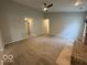 Spacious living room with neutral walls and carpet, a ceiling fan, and plenty of natural light at 7022 Cordova Dr, Indianapolis, IN 46221