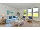 Bright living room featuring a light blue sofa set, wicker chairs, and stylish beach-themed decor at 7147 Buckley Branch Dr, Indianapolis, IN 46259