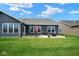 Spacious backyard features a patio with outdoor seating, a green lawn, and nice landscaping at 7184 Lillian Pl, Cumberland, IN 46229