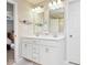 Bright bathroom features a dual sink vanity, ample lighting, and a separate door for privacy at 7184 Lillian Pl, Cumberland, IN 46229