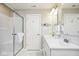 Well-lit bathroom with double sink vanity, a shower with glass door and a decorative wall hanging at 7184 Lillian Pl, Cumberland, IN 46229