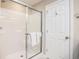 Bright bathroom featuring a shower with glass door and a white door at 7184 Lillian Pl, Cumberland, IN 46229