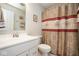 Clean bathroom with a patterned shower curtain, a white sink and vanity, and a framed picture at 7184 Lillian Pl, Cumberland, IN 46229