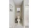 Bathroom featuring toilet, shower with glass door, and storage cabinet at 7184 Lillian Pl, Cumberland, IN 46229