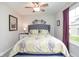 Comfortable bedroom with patterned quilt, a ceiling fan, and a window with curtains at 7184 Lillian Pl, Cumberland, IN 46229