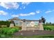Grant's Corner community entrance with stone pillars, wood accents, and beautifully landscaped surroundings at 7184 Lillian Pl, Cumberland, IN 46229