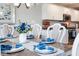 Formal dining room table is set with blue accents, and the kitchen is in the background at 7184 Lillian Pl, Cumberland, IN 46229