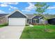 Well-maintained single Gathering home with attached garage, lush lawn, and tasteful landscaping at 7184 Lillian Pl, Cumberland, IN 46229