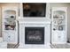 A close up of a stunning fireplace with marble surround and built-in shelving on either side at 7184 Lillian Pl, Cumberland, IN 46229