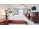 Comfortable main bedroom boasts dark wood furniture, carpet flooring, and a window for natural light at 7184 Lillian Pl, Cumberland, IN 46229