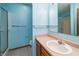 Bathroom with blue walls, including a sink and vanity, a mirror, and a shower with glass door at 7545 Briarstone Dr, Indianapolis, IN 46227