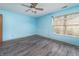 Bedroom with light blue walls, vinyl floors and large window offering ample natural light, ready for personal touches at 7545 Briarstone Dr, Indianapolis, IN 46227