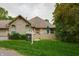 Brick home featuring a well-manicured lawn and garden area, complemented by mature trees and a 'For Sale' sign at 7545 Briarstone Dr, Indianapolis, IN 46227