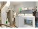 Well-equipped laundry room with front-loading washer, dryer, and ample shelving for storage at 7942 Dillon Pl, Indianapolis, IN 46236