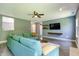 Comfortable living room features a teal sectional couch, ceiling fan, and wall-mounted TV at 7942 Dillon Pl, Indianapolis, IN 46236