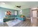 Spacious living room with modern teal sofa, neutral gray walls and floors, and view to kitchen at 7942 Dillon Pl, Indianapolis, IN 46236