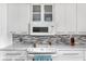 Close-up of the kitchen features white cabinets, modern appliances, and stylish backsplash at 842 Cheltenham Way, Avon, IN 46123