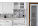 Bright kitchen features a farmhouse sink, stylish backsplash, white cabinets and door to pantry at 842 Cheltenham Way, Avon, IN 46123